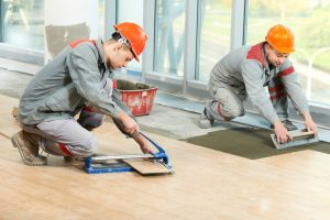 two workers lying tile